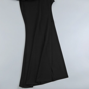 Detail of black evening dress featuring a high side slit and premium woven fabric texture