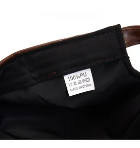 Detail view of the inner care label and stitching on a dark brown PU leather beret