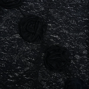Detail of black textured fabric featuring 3D floral accents and white speckle patterns