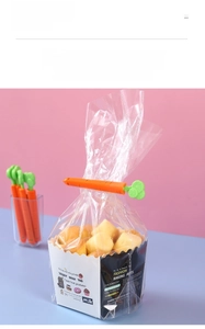 Pince de scellage en forme de carotte fermant un sachet de nourriture sur un fond rose