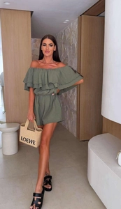 Detail of layered ruffles and textured fabric on a green off-the-shoulder romper