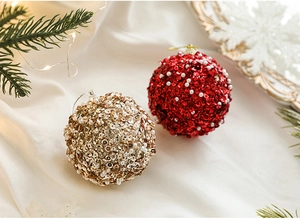 Detail of red and gold 8cm Christmas baubles with sparkling sequins and faux pearls