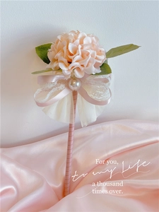 Detail of flower wand with champagne hydrangea, pink lace ribbon, and large pearls decoration
