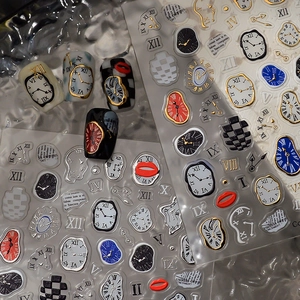 Close-up of surrealist melting clock nail stickers with gold embossed details