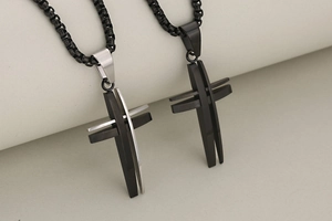 Detail of hollow 3D stainless steel cross pendants in black and silver finishes