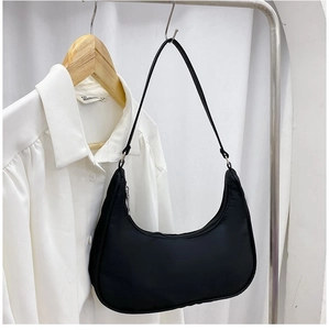 Detail view of a black nylon hobo bag featuring a silver metal zipper and slim strap