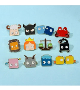 Flat lay of twelve cute cartoon zodiac animal enamel pins on a light blue background