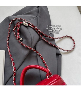 Detail of red quilted leather handbag with adjustable silver metal chain strap