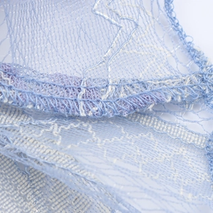 Gros plan sur la jupe en dentelle bohème bleu clair avec broderie blanche et mesh