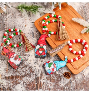 Detail of Christmas gnome ornaments with wooden beads, tassels, and Merry Christmas text