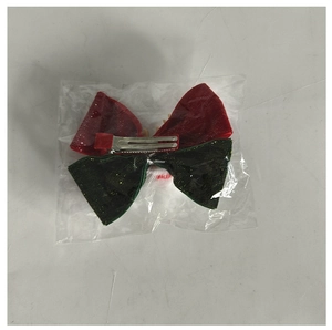 Detail of festive red and green bow hair clip with glitter fabric and metal duckbill clip