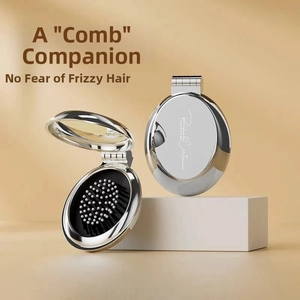 Close-up of portable folding hairbrush with mirror in silver metallic finish