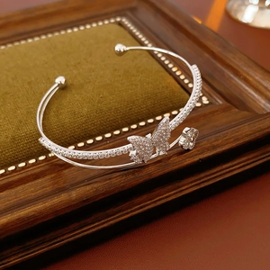 Detail of silver double-layered butterfly flower bangle with zircon accents