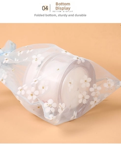 Macro bottom view of blue organza gift bag with white floral pattern and gold glitter