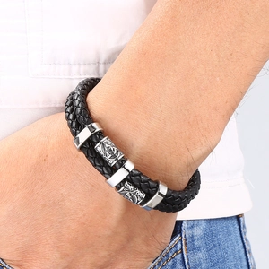 Gros plan du bracelet pour homme en cuir tressé noir avec perles en métal argenté gravées