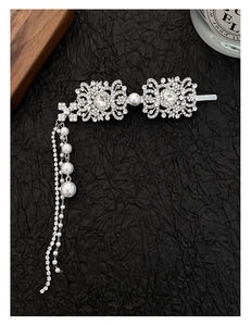 Detailed view of silver hair clip with rhinestones, pearls and elegant tassels