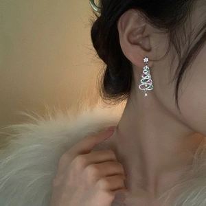 Close-up of Christmas tree drop earrings with colorful tassels and sparkling rhinestones