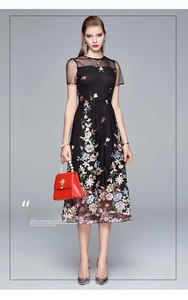 Detail of colorful floral embroidery on a black high-waist elegant mesh midi dress