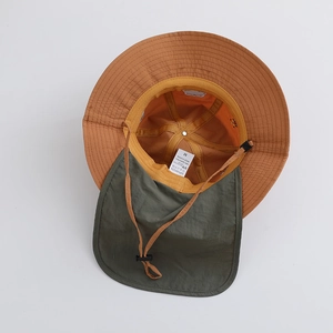 Detail of nylon sun hat showing adjustable chin strap and UV protection interior label