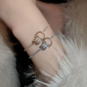 Détail macro de bracelets plaqués or et argent avec pierres en zircon et breloques en anneau