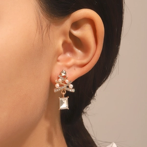 Detailed macro view of rhinestone Christmas tree earrings with pearl and crystal drop on model