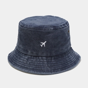 Détail du bob en coton délavé bleu marine avec broderie d'avion blanche discrète