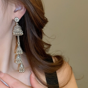 Detailed close-up of vintage silver multi-layer tiered bell earrings in ethnic style