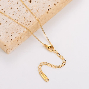 Detail of 18KGP gold-plated chain with lobster clasp and extension on a stone base