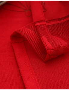 Detailed close-up of red Christmas lace tablecloth showing mesh texture and fine stitching