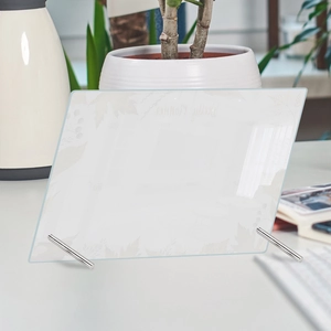 Detail view of acrylic weekly planner board on desk with metal stands and plants