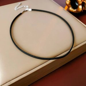 Close-up of black leather choker necklace with silver adjustable chain and clasp