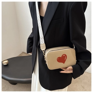Beige rectangular leather crossbody bag with red heart and geometric woven strap