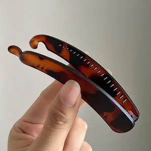 Amber tortoiseshell banana clip with inner teeth for volume enhancement and ponytail styling