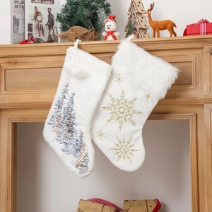 Set of 2 white plush Christmas stockings with tree and snowflake embroidery hanging on fireplace