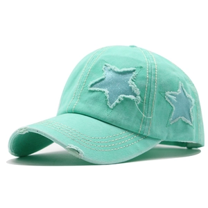 Détail de la casquette en coton vert menthe avec écusson étoile et bords de visière usés