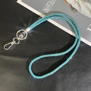 Macro detail of luxury light blue rhinestone phone strap with shiny silver metal clasp