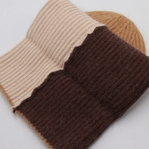 Dettaglio della trama a coste in maglia beige e marrone scuro di un cappello invernale
