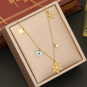 Gold stainless steel necklace with evil eye heart and snowflake charms in a jewelry box