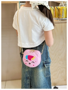 Pink cartoon animal crossbody bag for kids with gold chain strap shown on model