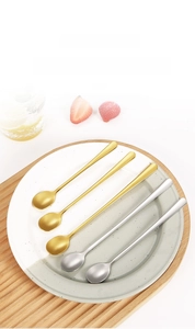 Detailed view of long-handled stainless steel stirring spoons in gold and silver finish