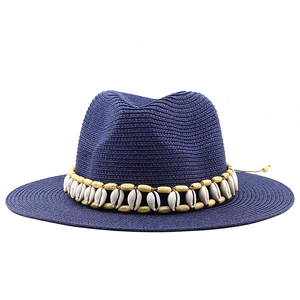 Close-up of a blue woven Fedora straw hat with white shells and wood bead decoration