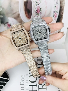 Montre de luxe pour femme en forme de tonneau, finitions or et argent avec cristaux