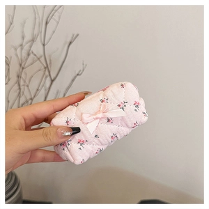 Close-up of pink floral quilted cotton pouch with a cute bow detail for storage