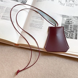 Detail of burgundy faux leather magnetic eyewear holder with contrast stitching on magazine