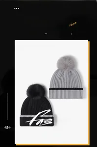 Detail of color-block knit beanie with thick fur pompom showing high elasticity texture