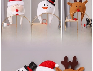 Detailed view of plush Christmas earflap hats featuring Santa, Snowman and Reindeer designs