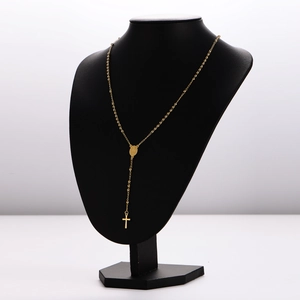 Collana lunga con perline dorate e ciondolo a croce su manichino nero da esposizione