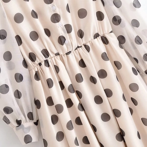 Détail de la robe beige à pois avec taille élastique, boutons frontaux et manches voilées