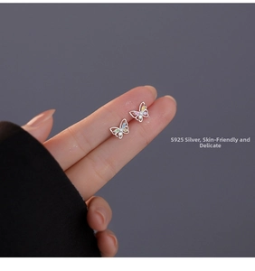 Macro detail of S925 silver butterfly earrings featuring colorful zircon inlay on fingers