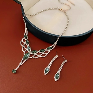 Detailed view of rhinestone tassel necklace and earrings set in a navy gift box